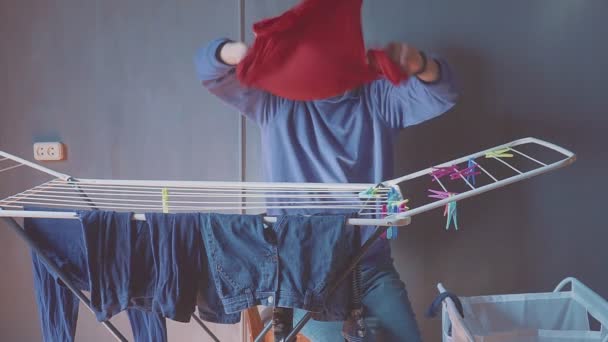 L'homme accroche des vêtements au sèche-linge. Des vêtements pour enfants. Père solitaire — Video