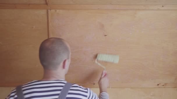 Travailleur peint un grenier en bois. Traitement de surface du bois . — Video