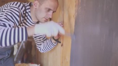 İşçi ahşap tavan arasını boyuyor. Ahşap yüzey tedavisi. Yakın plan portre