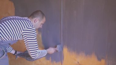 İşçi ahşap tavan arasını boyuyor. Ahşap yüzey tedavisi.