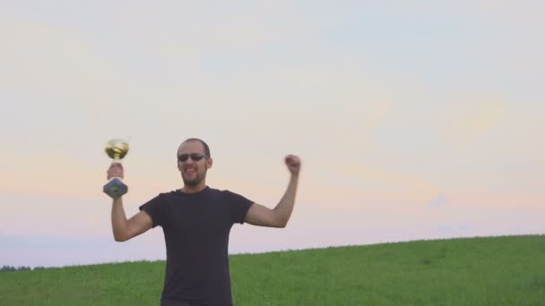 El ganador con una gorra en las manos levanta las manos, disfruta del éxito . — Vídeos de Stock