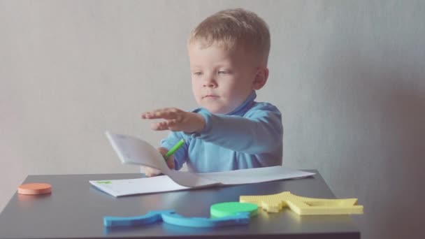 Two year old boy is drawing with marker at album — Stock Video