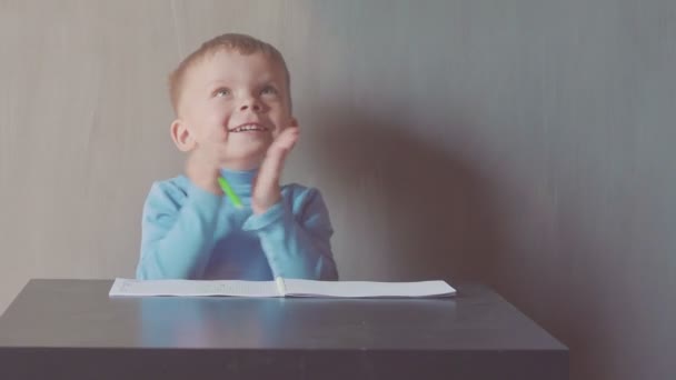 Дворічний хлопчик малює з маркером на альбомі — стокове відео