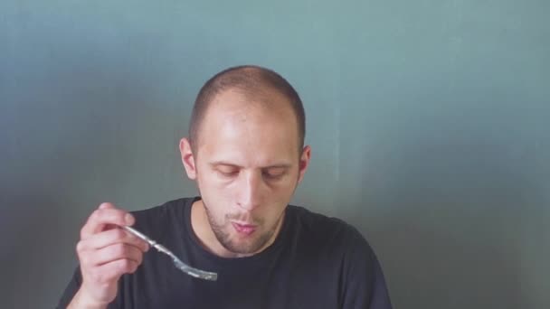 Joven barbudo comiendo y usando teléfono móvil aislado — Vídeos de Stock