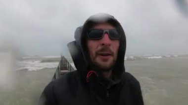 siyah giysiler içinde balıkçı veya denizci Kötü ve Fırtına Hava, İtalya, Rimini deniz yakınında duran.