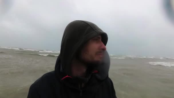 Рыбак или моряк в черной одежде, стоящий у моря в плохую и бурную погоду, Италия, Римини . — стоковое видео
