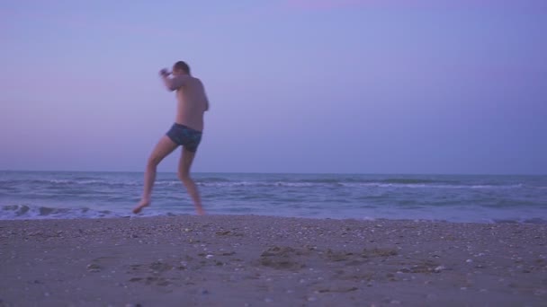 Hombre feliz bailando en la playa al atardecer — Vídeos de Stock