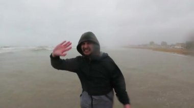 siyah giysiler içinde balıkçı veya denizci Bad ve Fırtına Hava, İtalya, Rimini deniz yakınında ayakta. Sos