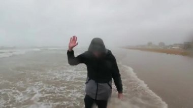siyah giysiler içinde balıkçı veya denizci Bad ve Fırtına Hava, İtalya, Rimini deniz yakınında ayakta. Sos