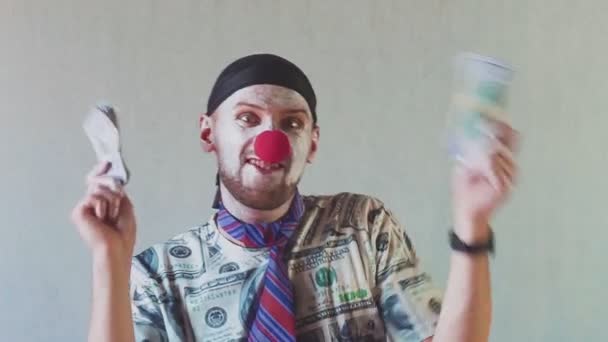 Lustiger Clown-Geschäftsmann in einem T-Shirt aus Dollars und mit Dollars in den Händen. Tanzen und ihren Reichtum genießen. Konzept für Big Boss mit Geld. — Stockvideo