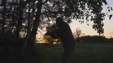 Ormanda odun kesen güçlü bir oduncu. Günbatımı