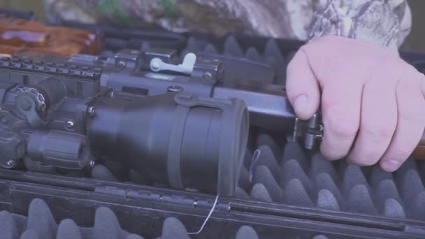 Mãos de um caçador ou franco-atirador anexar uma visão noturna a um rifle de caça — Vídeo de Stock