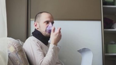 Odadaki inhaler maskesi ile teneffüs adam.