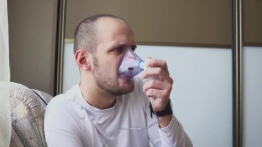 Odadaki inhaler maskesi ile teneffüs adam.