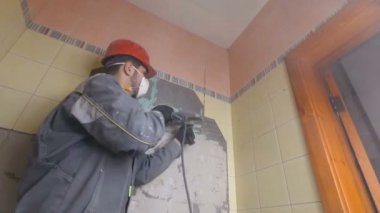 Kaya matkabıyla eski fayansların yıkılması. Banyo veya mutfaktaki eski duvarların yenilenmesi