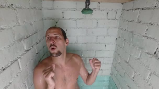 Joven guapo divertido hombre toma una ducha. baila en la ducha. cámara lenta — Vídeos de Stock