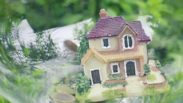 Op het huis geld vallen. Muntgeld en huis model. Finance and Banking concept. Slow Motion — Stockvideo