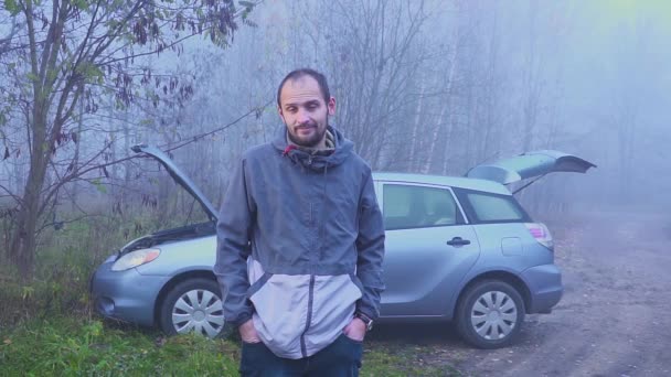 Portrait of sad man who standing near broken car with open hood — Stock Video