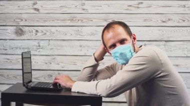 Hasta işadamı sıcaklık ve çalışma office baş ağrısı ile dizüstü bilgisayar kullanın. Öksürük ile yüz maskesi giyen adam.