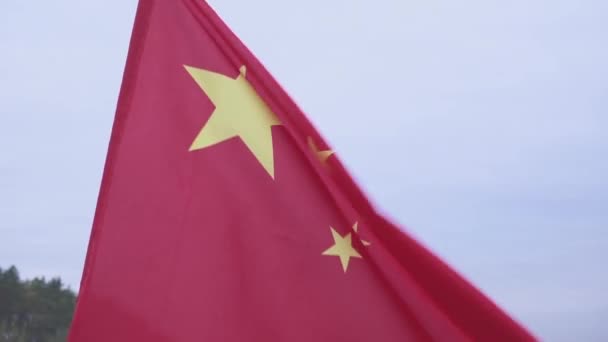 A acenar com a bandeira chinesa. Bandeira da República Popular da China contra o céu azul . — Vídeo de Stock