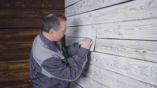 L'ouvrier mesure un mur de bois avec une règle — Video