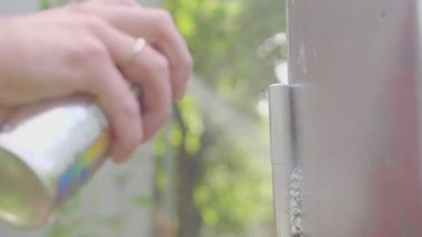 Sokak sanatı sanatçısı sprey boya şişesi ile çizer. Sokak boyama sanatı. Sanat yaratma sürecinde sanatçı