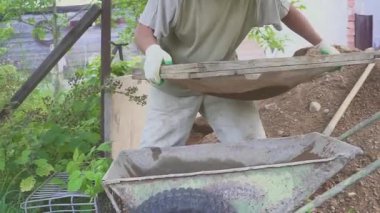 Eldivenli ellerle kum temel üzerine yerleştirerek bir kaldırım tuğla döşeme Oluşturucu.