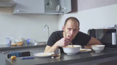 Masadaki Makarna yiyen üzgün adam. Mutfağında ev. Sorunları yüzünden endişeleniyor..