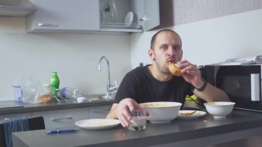 Masadaki Makarna yiyen üzgün adam. Mutfağında ev. Sorunları yüzünden endişeleniyor..