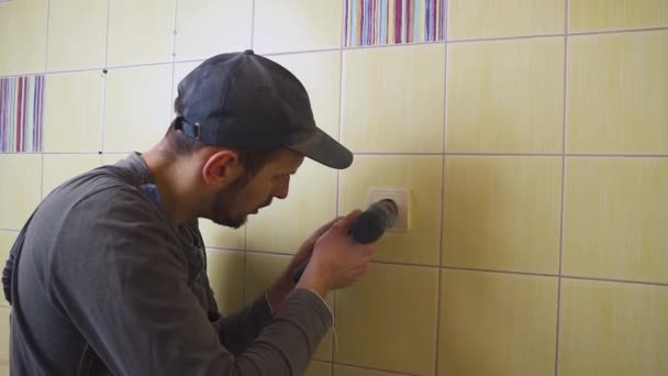 Close-up of an electrician with a screwdriver seting up a white outlet. — Stock Video