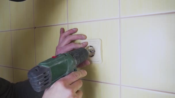 Uzavření elektrikáře se šroubovákem, který vystříkne bílou zásuvku. — Stock video