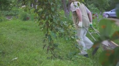 El arabası ile Bahçıvan adam kırsal yol bahçe arka bahçesinde gidiyor. Sert fiziksel emek