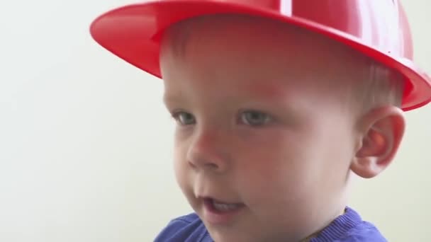 Joven lindo constructor niño en uniforme y casco o casco con destornillador eléctrico contra el fondo de la construcción y la reparación . — Vídeos de Stock