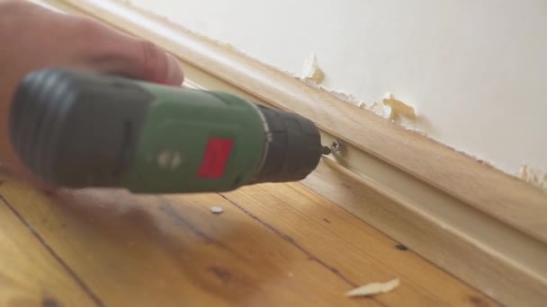 De schroevendraaier is geschroefd op de ontmanteling van de plint — Stockvideo