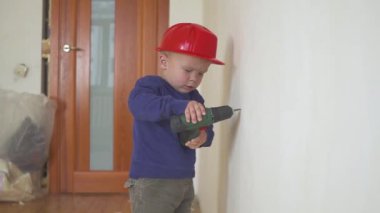 Genç Sevimli Oluşturucusu çocuk tek tip ve sabit hat veya kask ile inşaat ve onarım arka planı Elektrikli tornavida.