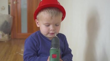 Genç Sevimli Oluşturucusu çocuk tek tip ve sabit hat veya kask ile inşaat ve onarım arka planı Elektrikli tornavida.