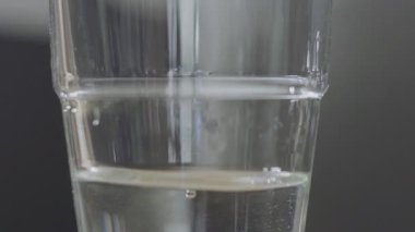 gerçek arka planda şeffaf cama dökülen su. Yavaş çekim