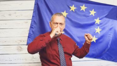 Basın toplantısında konuşma yapan ya da arka planda Avrupa Birliği bayrağıyla buluşan siyasetçi