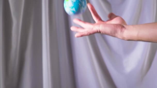 The hand is holding and throwing up the globe. The world is in your hands. Slow motion — Stock Video