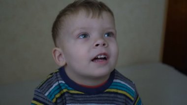 Bir iki yıl yaşlı erkek çocuk ev bir projektör film izliyor, kapat.