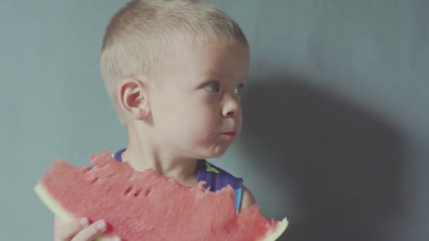 Feliz niño sonriente apetitoso comiendo sandía roja y jugo que fluye debajo de la boca — Vídeo de stock