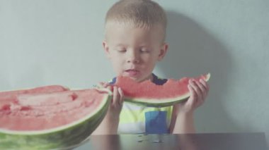 Mutlu gülümseyen çocuk iştah açıcı kırmızı karpuz ve meyve suyu ağız altında akan yeme