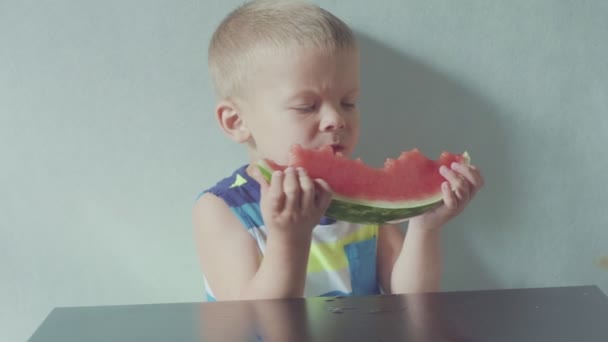 Feliz niño sonriente apetitoso comiendo sandía roja y jugo que fluye debajo de la boca — Vídeos de Stock
