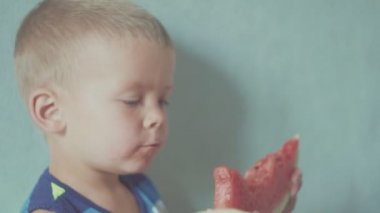 Mutlu gülümseyen çocuk iştah açıcı kırmızı karpuz ve meyve suyu ağız altında akan yeme