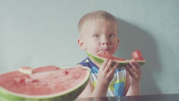 Glücklich lächelnder Junge appetitlich essen rote Wassermelone und Saft fließt unter dem Mund — Stockvideo