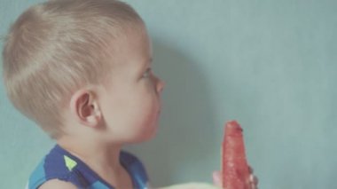 Mutlu gülümseyen çocuk iştah açıcı kırmızı karpuz ve meyve suyu ağız altında akan yeme