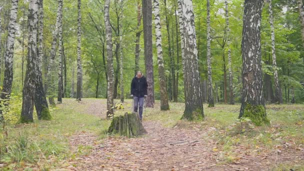 Młody człowiek chodzący po kulach w naturze — Wideo stockowe