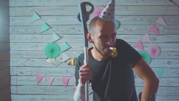 Hombre lesionado celebrando su cumpleaños en casa con muletas en la mano — Vídeos de Stock