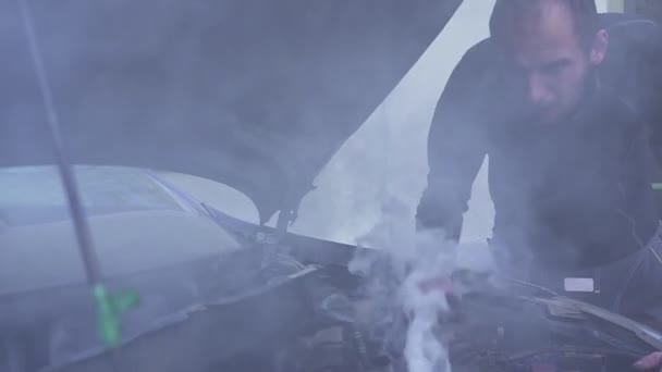 Bir adam dumanı tüten araba motorunu değerlendirirken hayal kırıklığına uğrar.. — Stok video