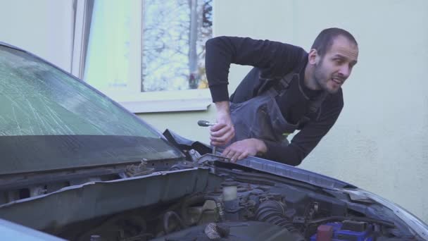 Mecánico masculino reparando su coche. Mecánico perdedor — Vídeo de stock